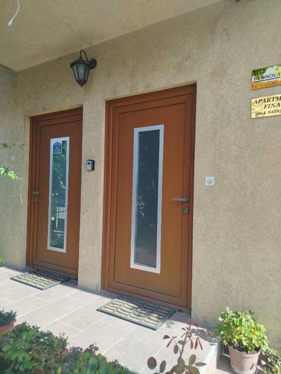 two brown doors on the side of a building at Fina Apartman in Leskovac