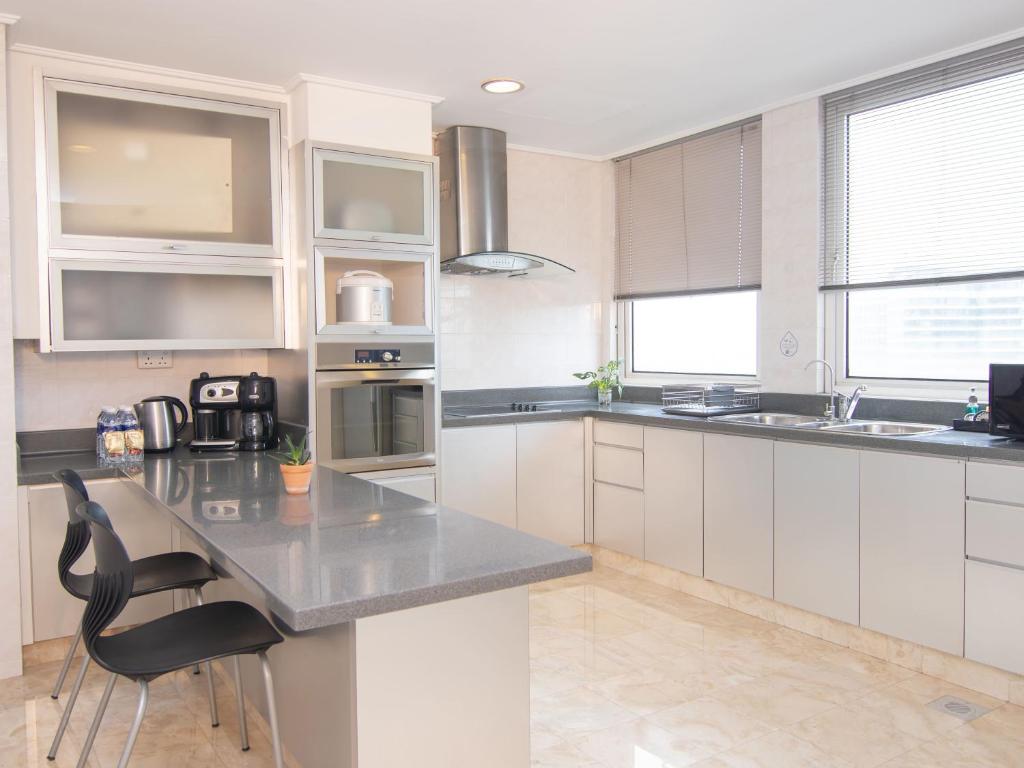 A bright fitted kitchen with a breakfast island, full-size appliances and broad windows.