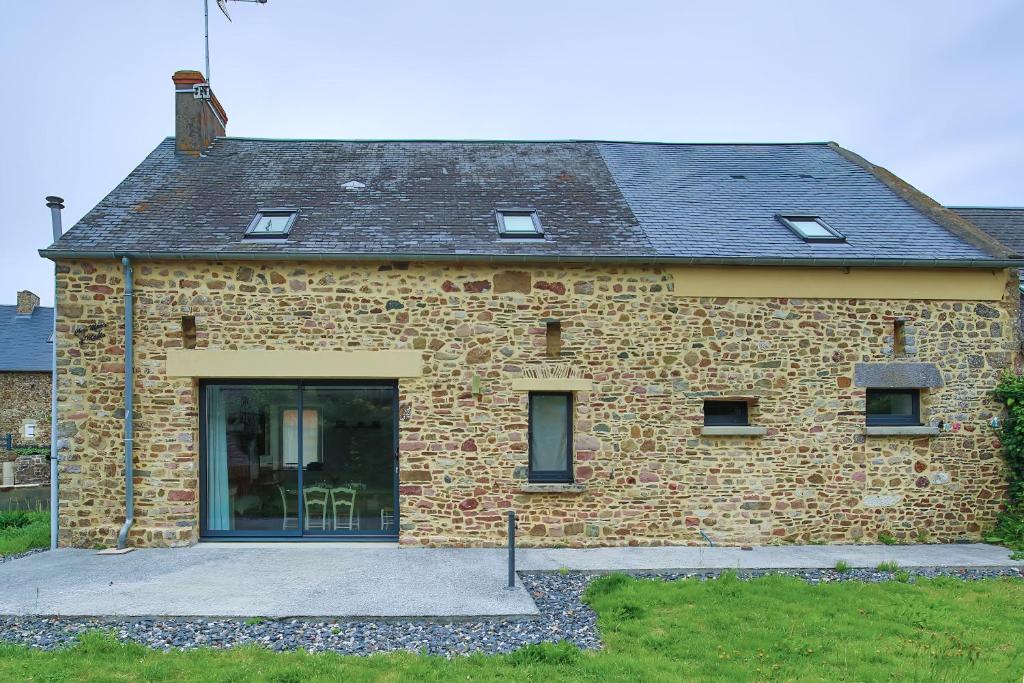 a brick house with a large glass door at Chez Manie Et Mablot in Créances