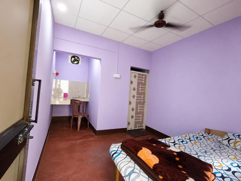 a bedroom with purple walls and a bed and a ceiling at Pranoti guest house in Dibrugarh