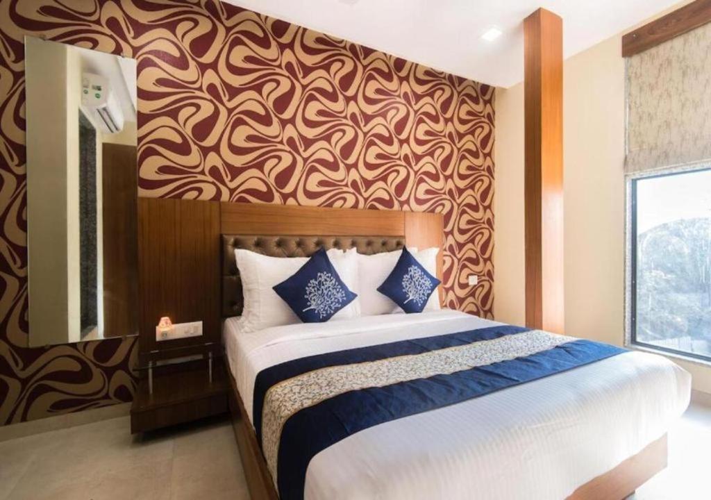 a bedroom with a large bed with a wall at Arton By Hotel Avion Palace - Near International Airport in Mumbai