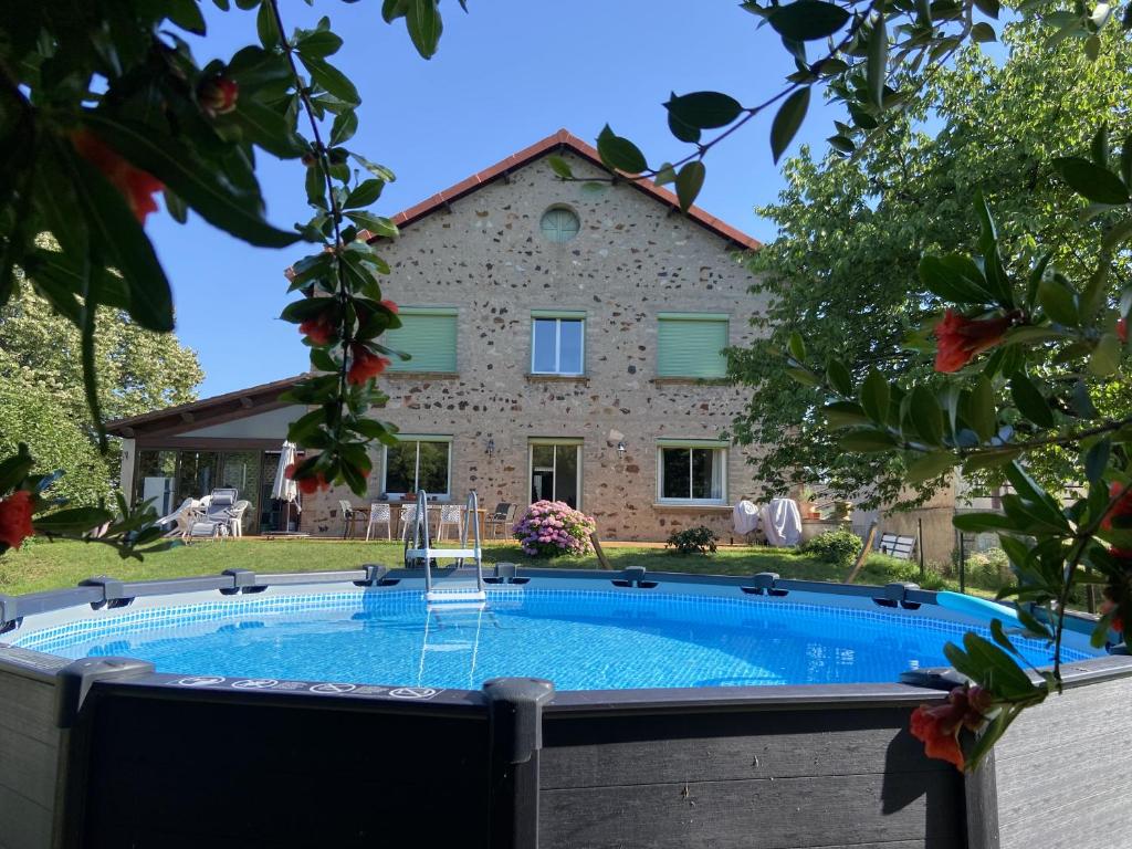 a house with a swimming pool in front of a building at Chambres et table d'hôtes Le Pontet in Arthès