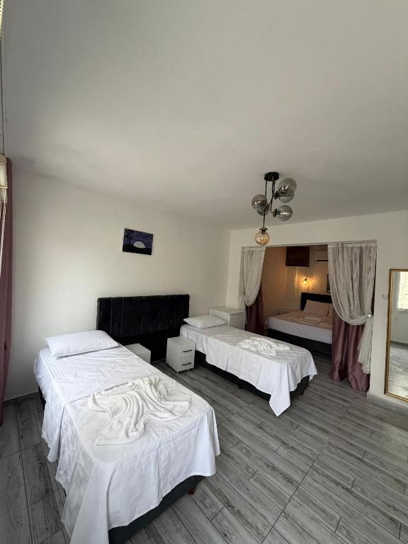 a hotel room with two beds in a room at Hotel Buse in Alaçatı