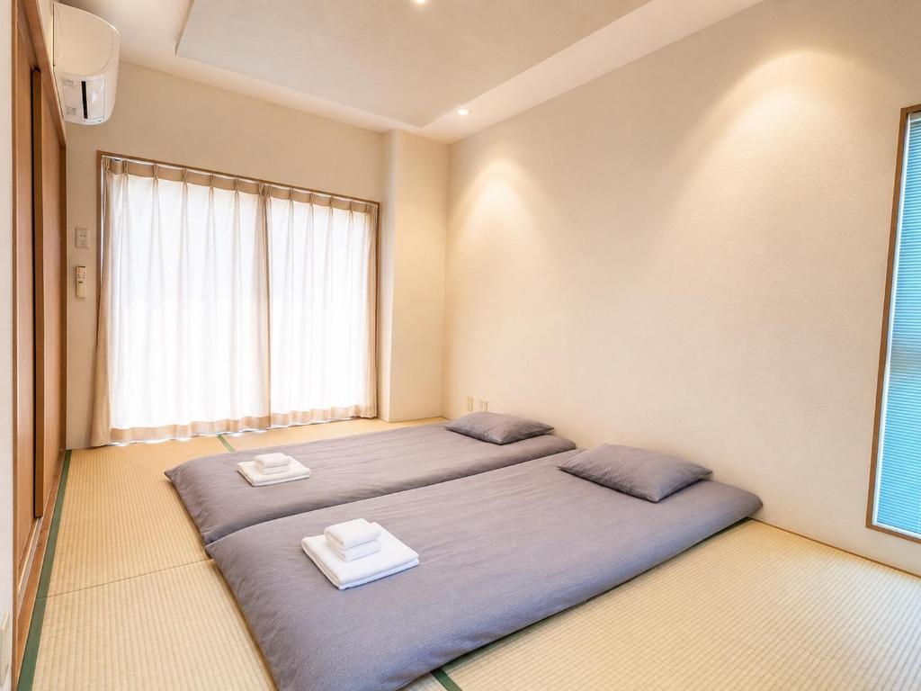 two beds in a room with a window at 晴の松 in Wakayama