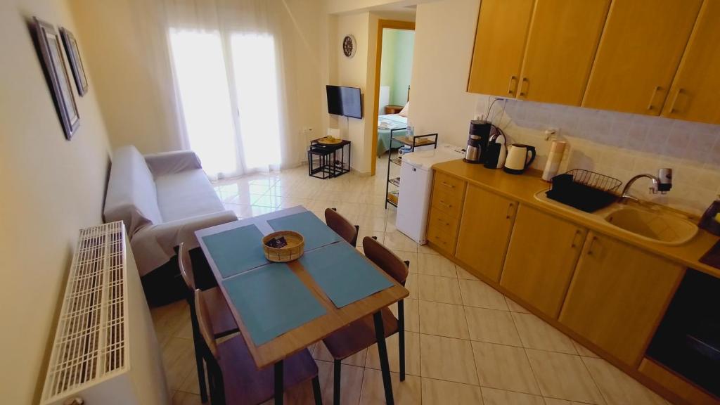 a living room with a table and a kitchen at Teos in Metamorfosi