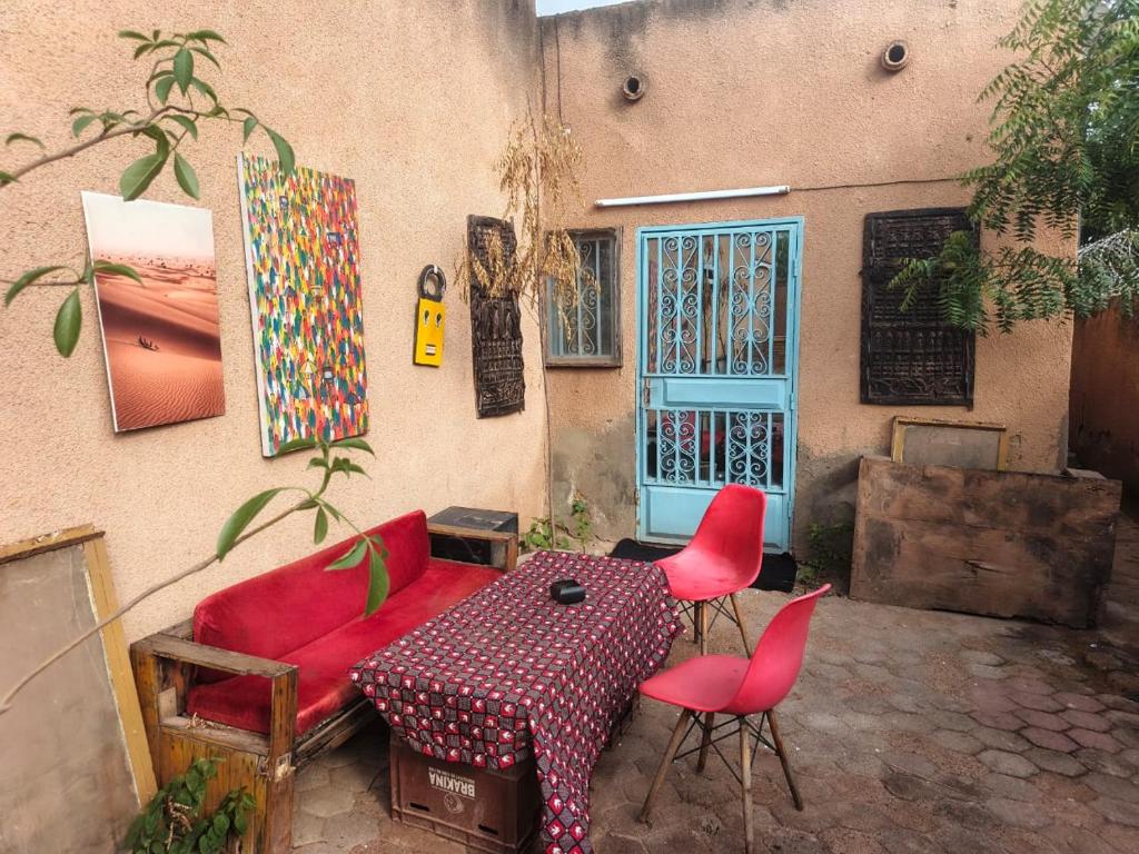eine Terrasse mit Tisch und Stühlen neben einem Gebäude in der Unterkunft RÉSIDENCE PRIVÉE 1 Chambre avec Salon, Cuisine Équipée, Climatisation, Wifi et Cour Individuelle in Ouagadougou