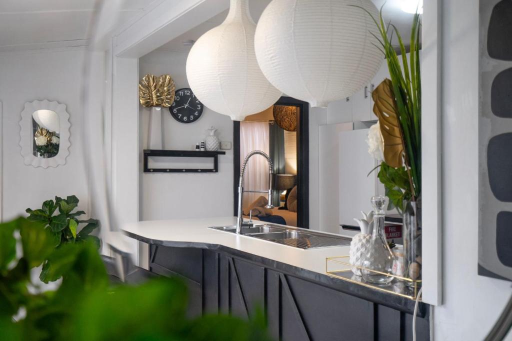 a kitchen with a sink and a mirror at Eleda House - Retro Hidden Gem in Cessnock