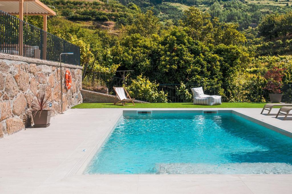 a swimming pool in the backyard of a house at Casa da Alufinha in São João da Fontoura