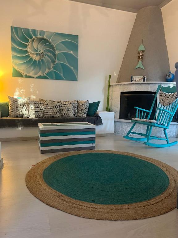 a living room with a green rug and a fireplace at jasmine apartments in Eretria