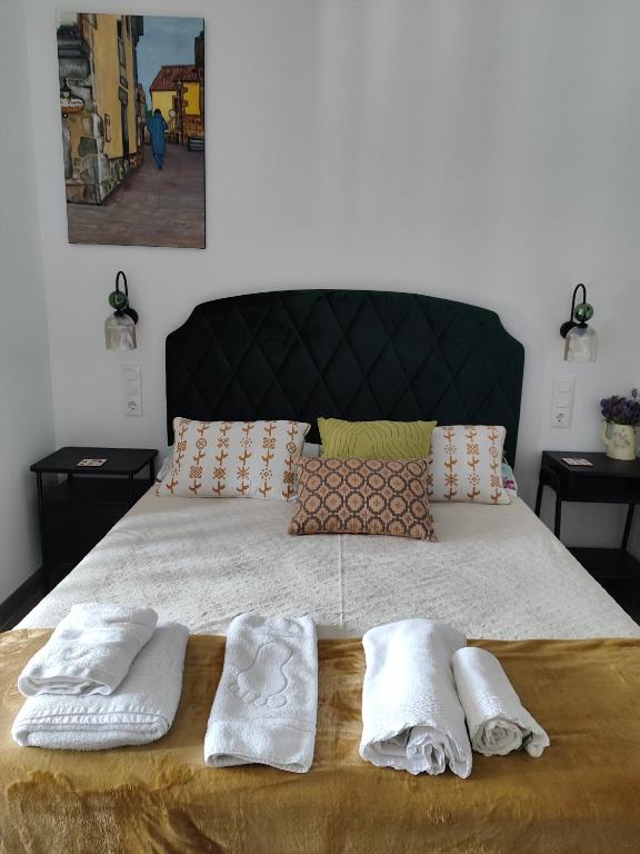 a bedroom with a bed with two towels on it at Magariños Apartamentos in Oia
