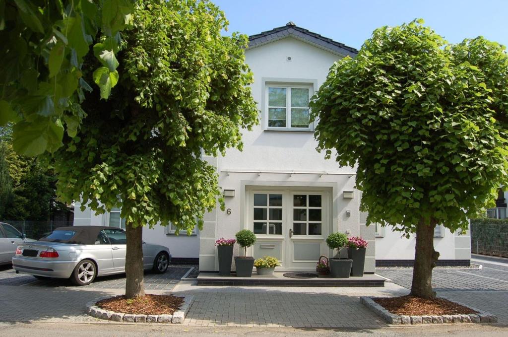 a white house with two trees in front of it at Ferienhaus Binz in Binz