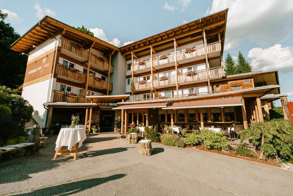 a large building with a table in front of it at Arlbergerhof Vital in Weissensee