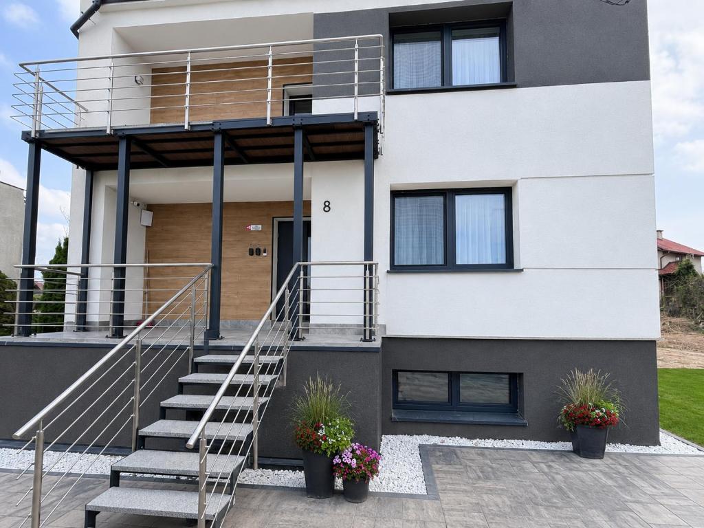 a house with a staircase in front of it at Apartamenty w Domu Bezpieczna Przystań in Frombork