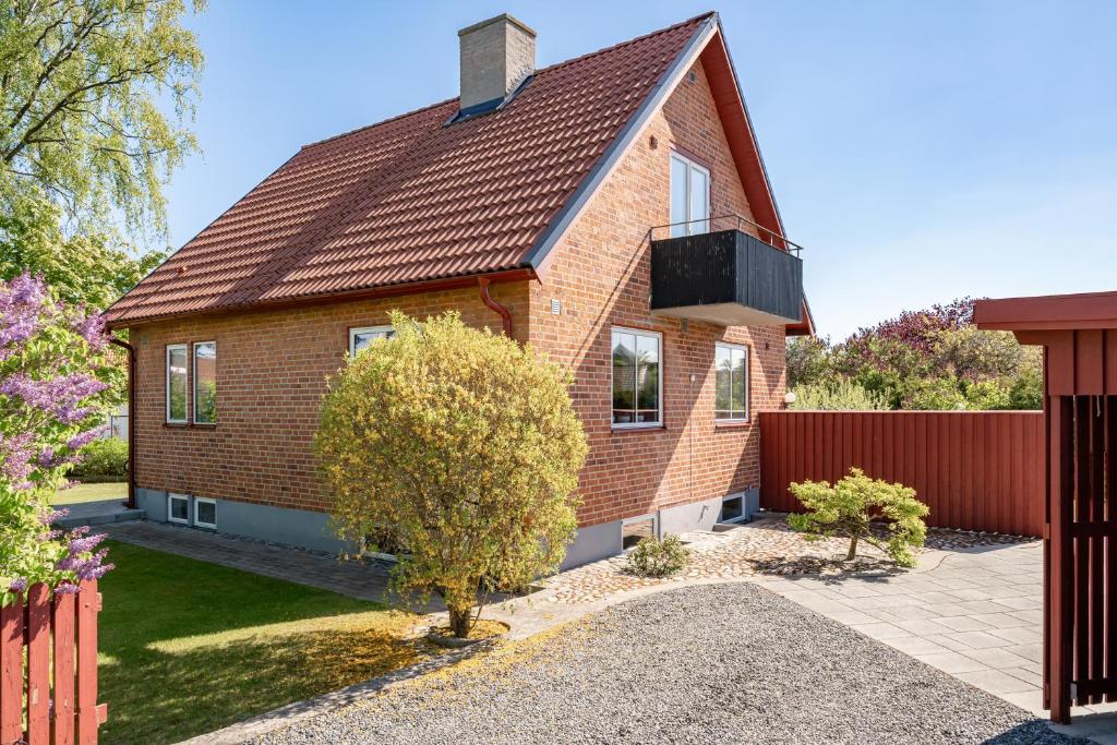 a red brick house with a brown roof at Kärraton Stugor Centrala Åhus in Åhus