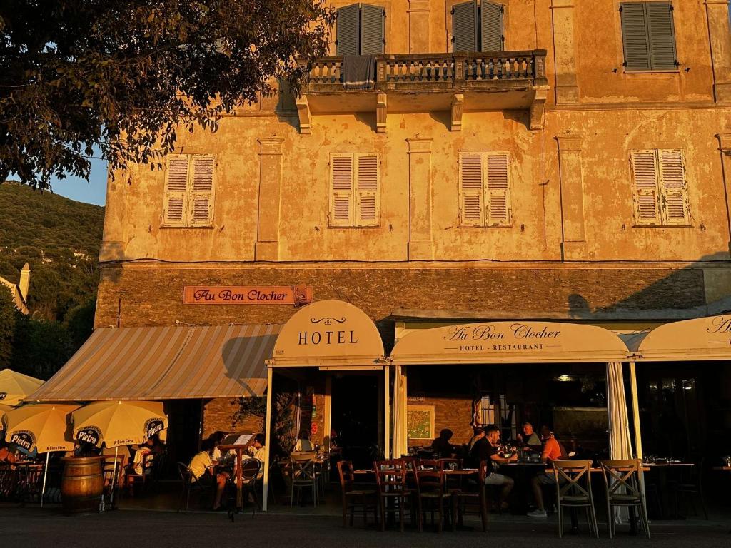 a restaurant with tables and chairs in front of a building at Au bon clocher in Canari