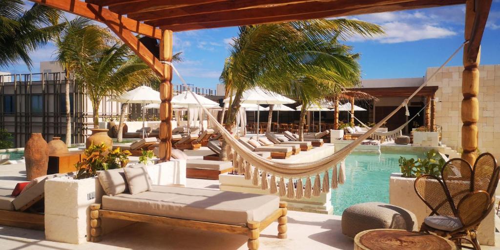 a resort with a hammock and a swimming pool at Motto By Hilton Tulum in Tulum