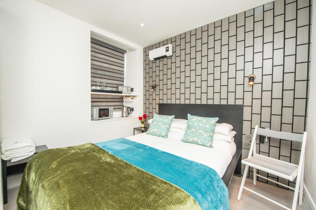 a bedroom with a bed and a chair in it at The Belmont Suits in Liverpool
