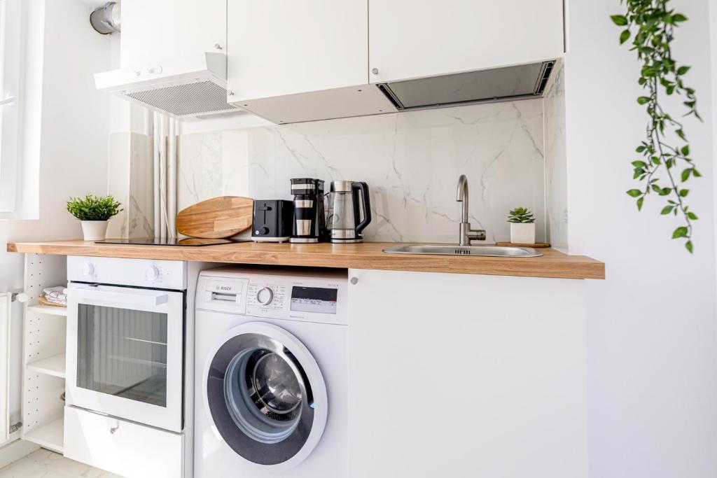 a kitchen with a washing machine and a sink at Deda Studio w. Smart TV · AC · washing machine in Bucharest