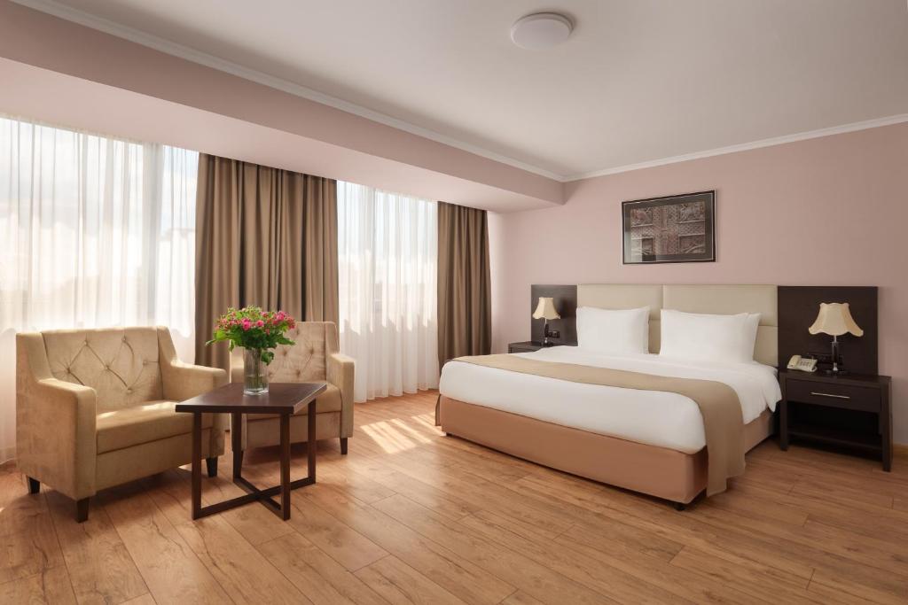 a hotel room with a bed and a chair at Ani Plaza Hotel in Yerevan