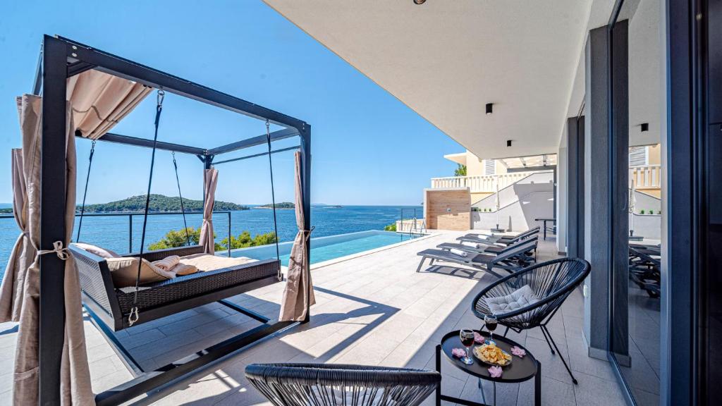 a balcony with a hammock and a view of the ocean at Villa Evia by Villas Guide in Smokvica
