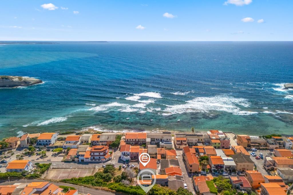 an aerial view of a beach with houses and the ocean at Estay - Zoe&Perla - Exclusive vacation near the beach in S'archittu Cuglieri