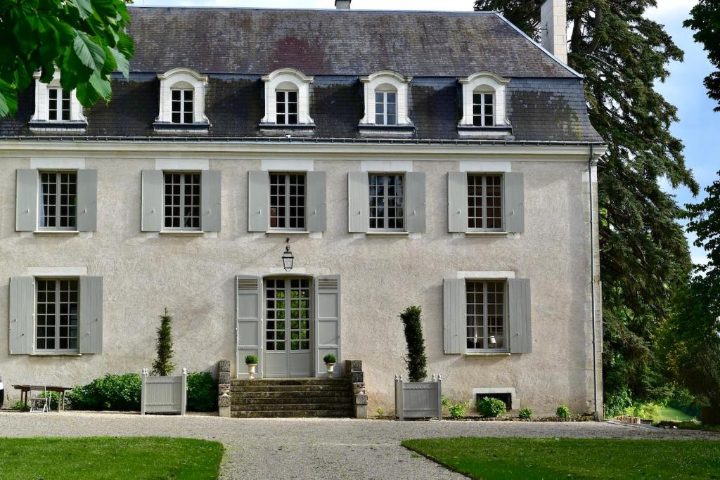 a large white house with white windows at Château de Chavigny in Chambourg-sur-Indre