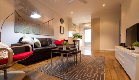 a living room with a couch and a table at Apartments by Townhouse in Wagga Wagga