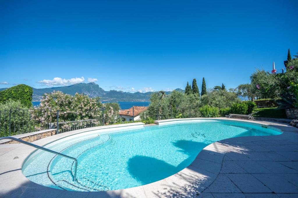 a large swimming pool with a blue at ApartmentsGarda - Villa Giada in Torri del Benaco