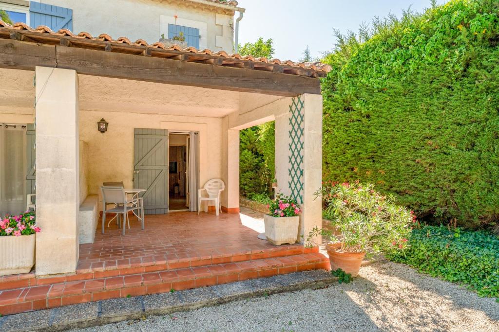 a house with a patio and a hedge at Studio meublé in Saint-Rémy-de-Provence