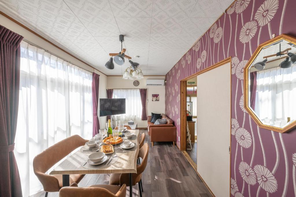 a dining room with a table and chairs and purple walls at Villa Yoko Gifu 4 Bedroom House 9 Guests Free Parking in Gifu