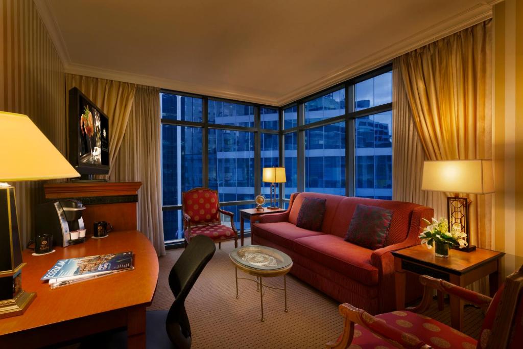 a living room with a red couch and a large window at Hotel Le Soleil by Executive Hotels in Vancouver