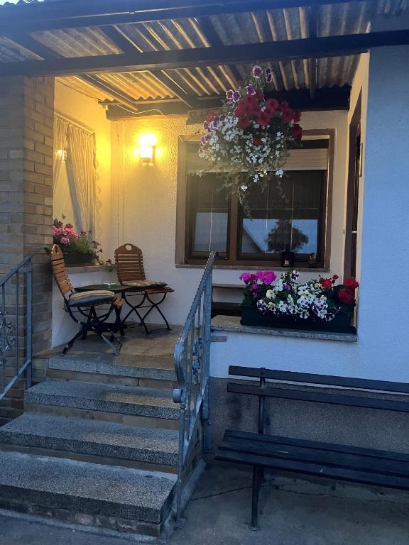 a porch with stairs and a table and flowers at Landhof Lindner in Lüptitz