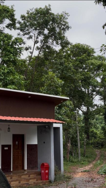 a small house with a red roof and some trees at BIG INN Resort in Mattanūr