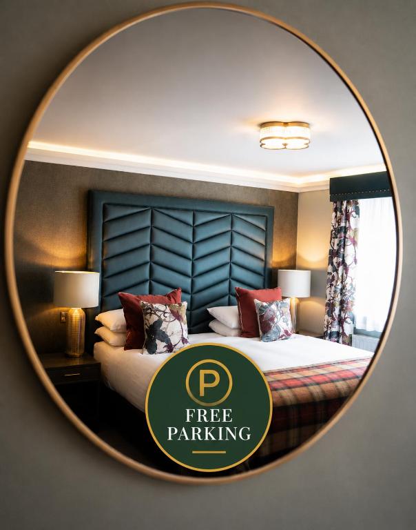 a mirror with a free parking sign in front of a bed at Beaufort Hotel in Inverness