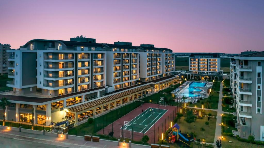 an aerial view of a hotel with a tennis court at Greenwood Suites Resort in Lara