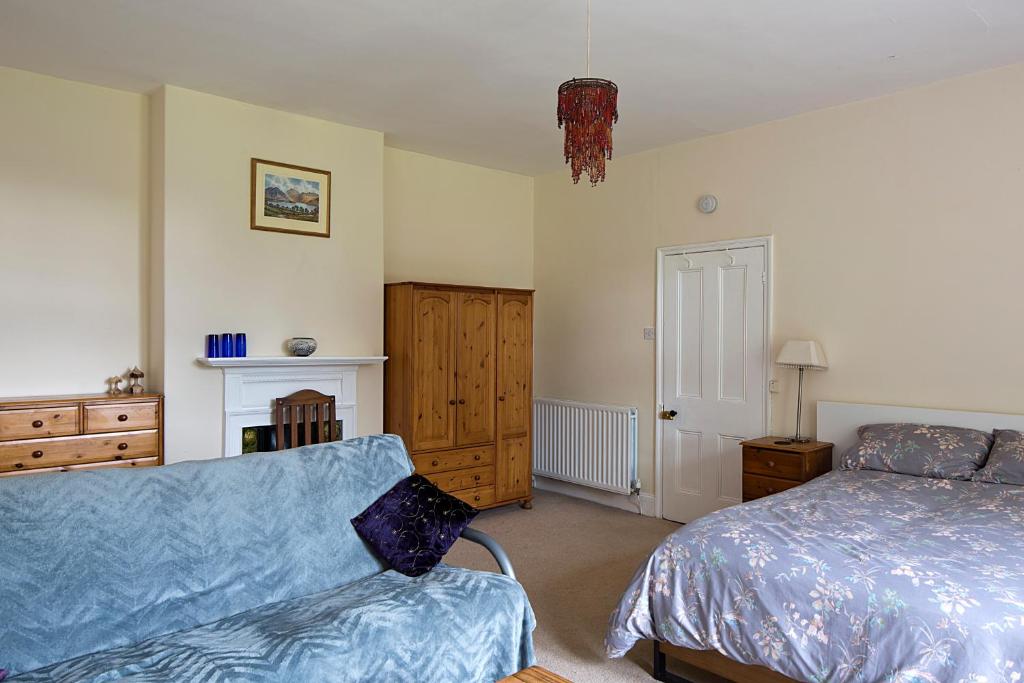a bedroom with a bed and a couch at Monument View in Hexham