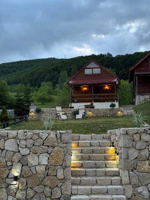 a house with a stone wall in front of it at HRID - vikendica u prirodi in Šavnik