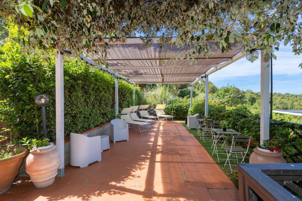a patio with tables and chairs under a pergola at Piccolo Paradiso - Montenero in Montenero