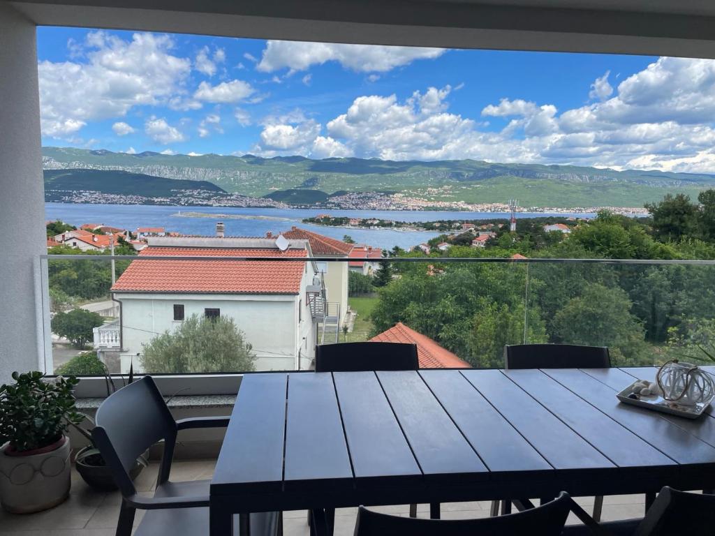 a table on a balcony with a view of a lake at Apartma LAVANDA 3 Šilo in Šilo