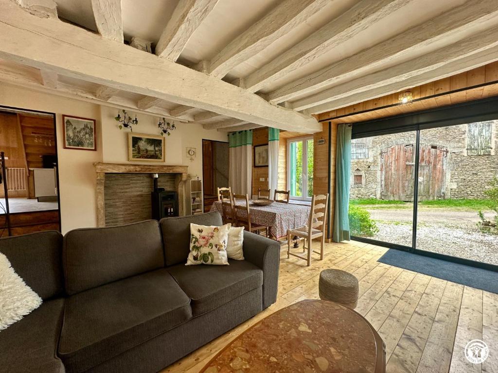 a living room with a couch and a table at Le gîte des oiseaux in Aisy-sous-Thil