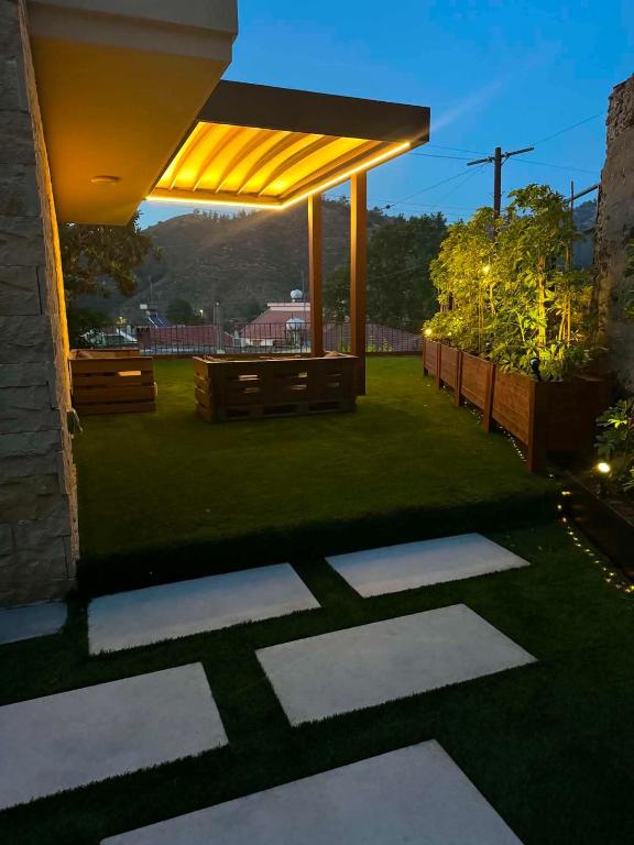 a backyard with a patio with a roof and grass at Le AVRA MONTIS in Galata