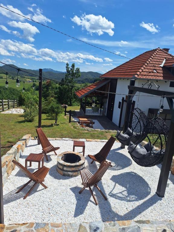 a group of chairs sitting around a fire pit at Planinska kuća Radulović in Goč