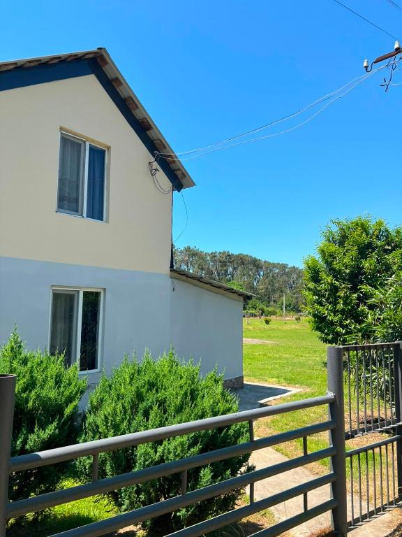 a white house with a fence and a field at Liza's house - Block B in Ureki