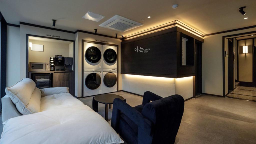 a living room with a white bed and a kitchen at Anook Stay Daejeon Daeheung in Daejeon