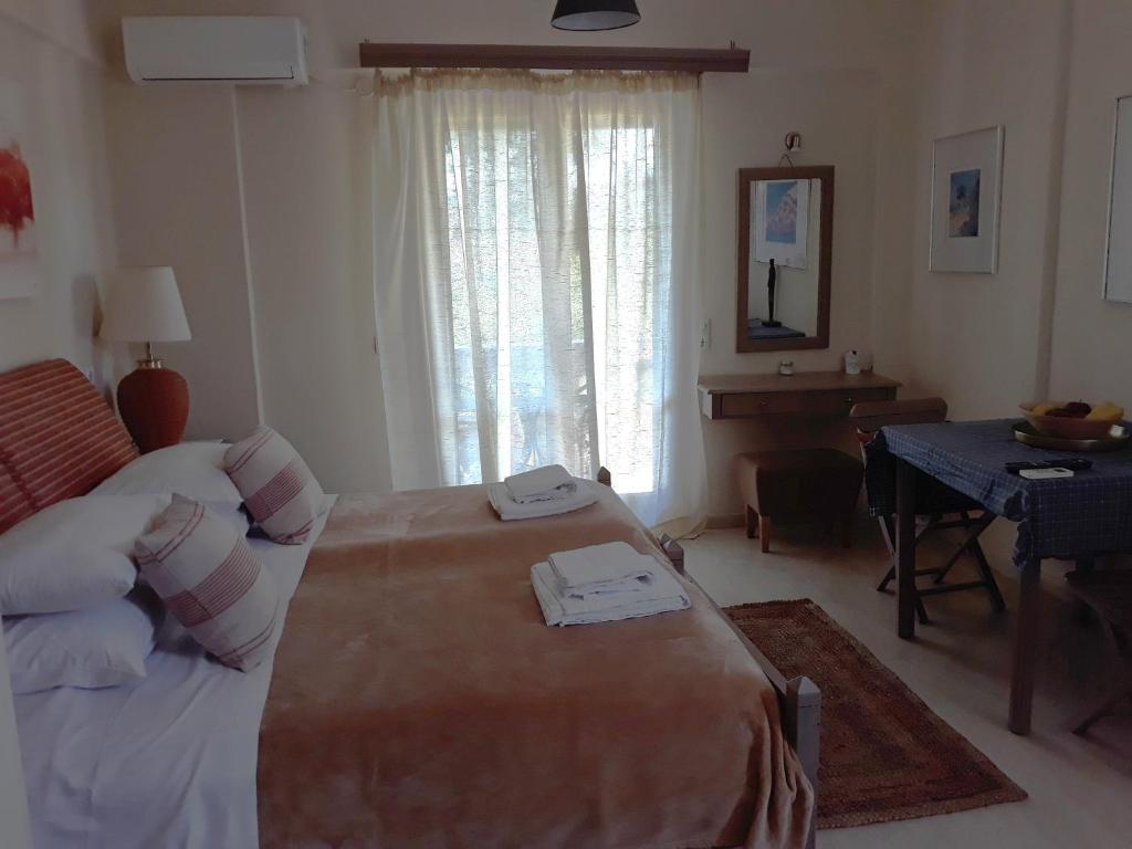 a bedroom with a bed and a desk and a window at Bright 2BR Apt Kitchenette Pool 3 in Gouvia