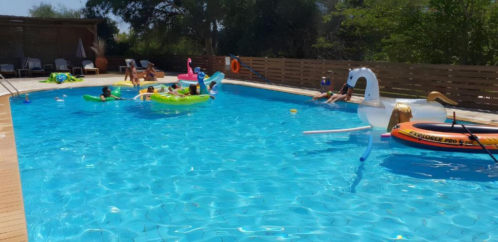 a group of children playing in a swimming pool at Family 2BR Apt Kitchenette Pool 7 in Gouvia