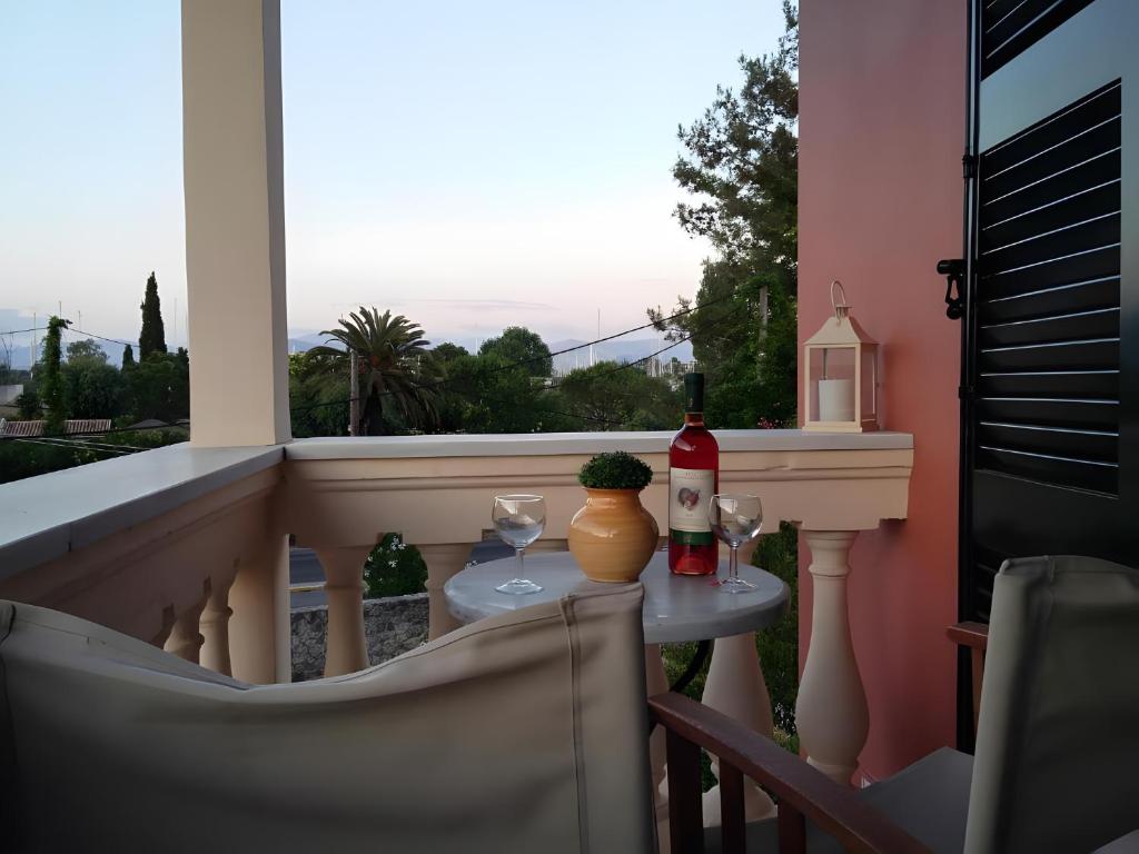 a balcony with a table with two bottles and glasses at 2BR Apt Kitchenette Pool 6 in Gouvia