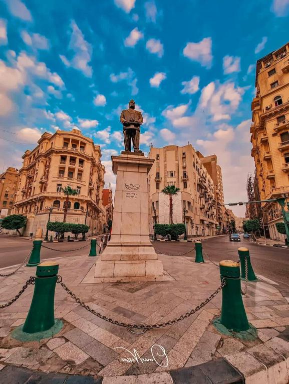 a statue in the middle of a street with buildings at swiss hotel cairo downtown in Cairo