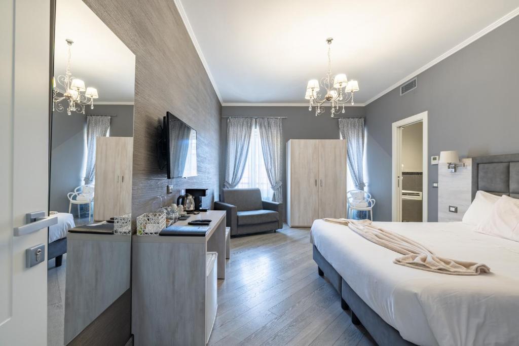a bedroom with a large bed and a living room at PRIMA FILA Premium Guest House in Sanremo