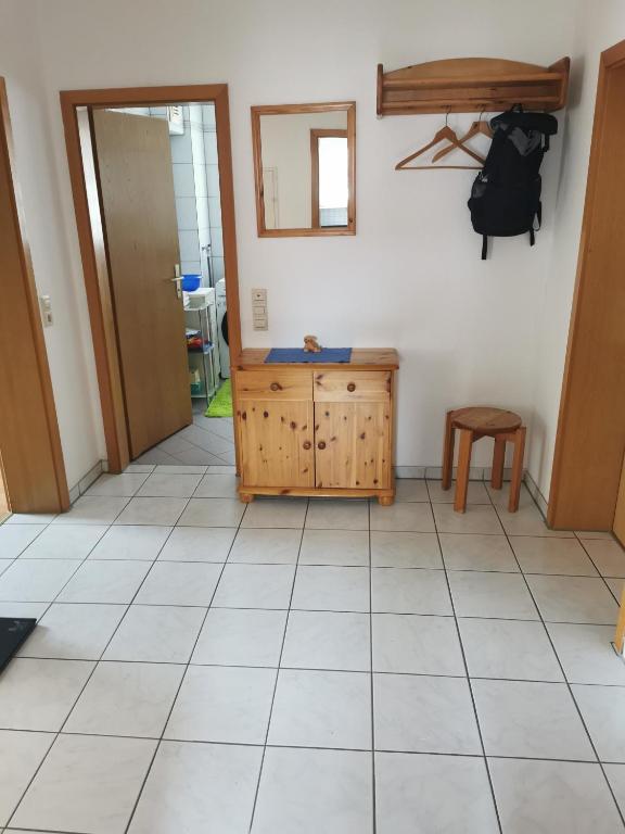 a room with a tiled floor and a wooden cabinet at Ferienwohnung Münsingen zentrum in Münsingen